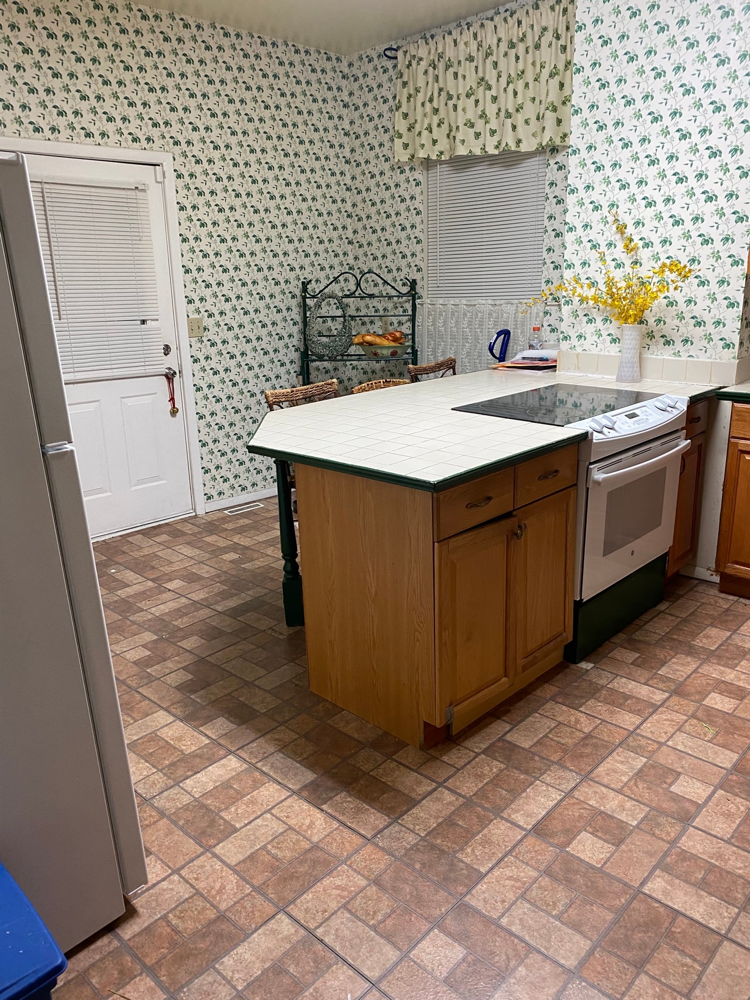 Shared kitchen with center island, refrigerator, stove, storage, and work surfaces